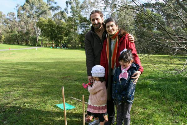 Mum, dad and two children planting a tree