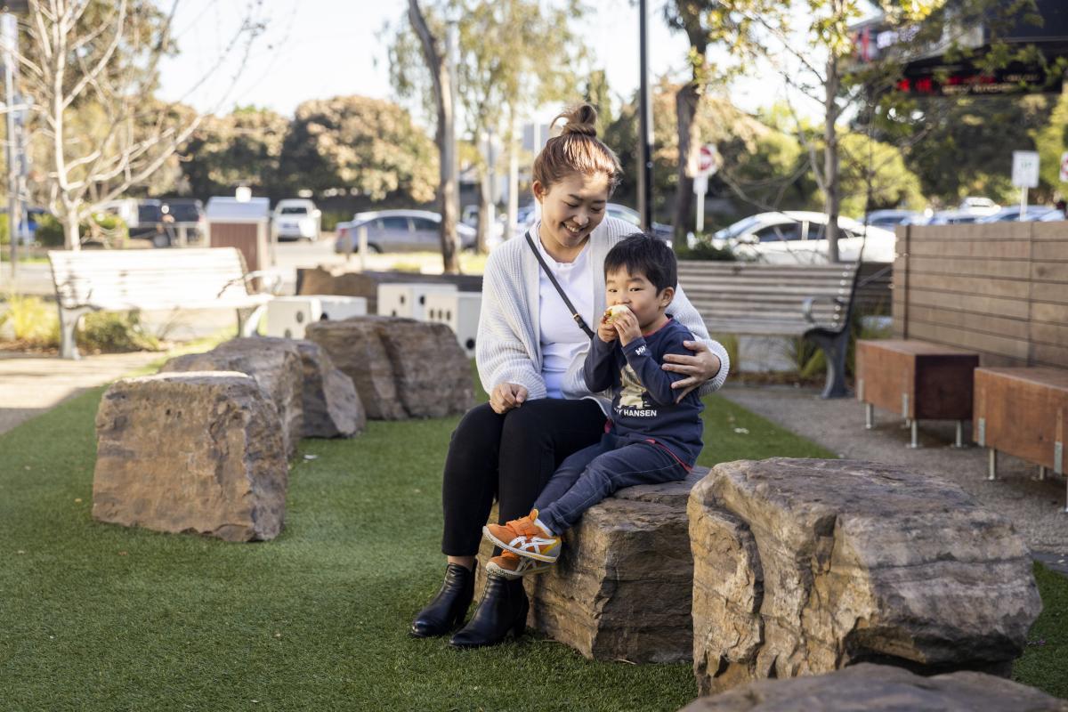 An image of a mother and her young son sitting in the Tunstall Square pop-up park. 