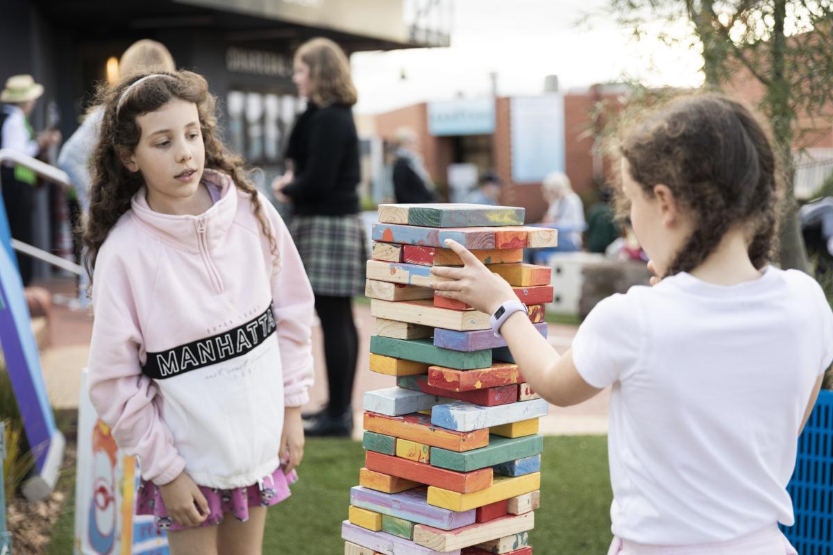 Two children playing with the giant Jenga at the Templestowe Village pop-up park