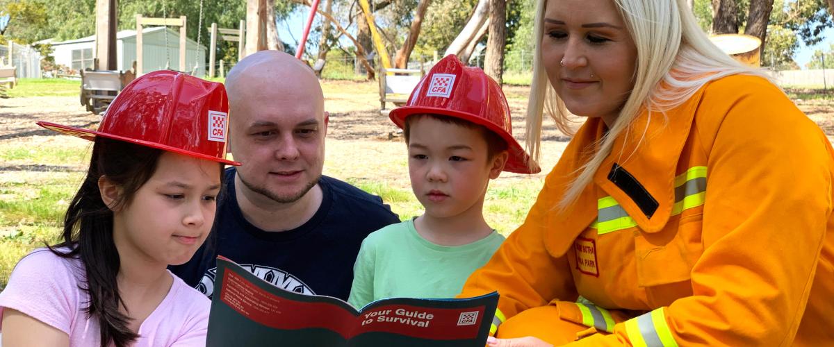 Two emergency workers reading to two kids
