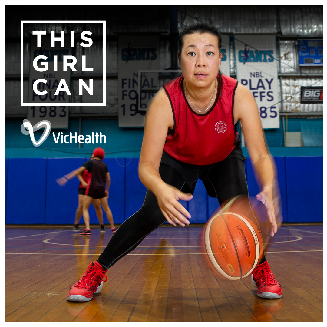 Lady in red singlet dribbling a basketball