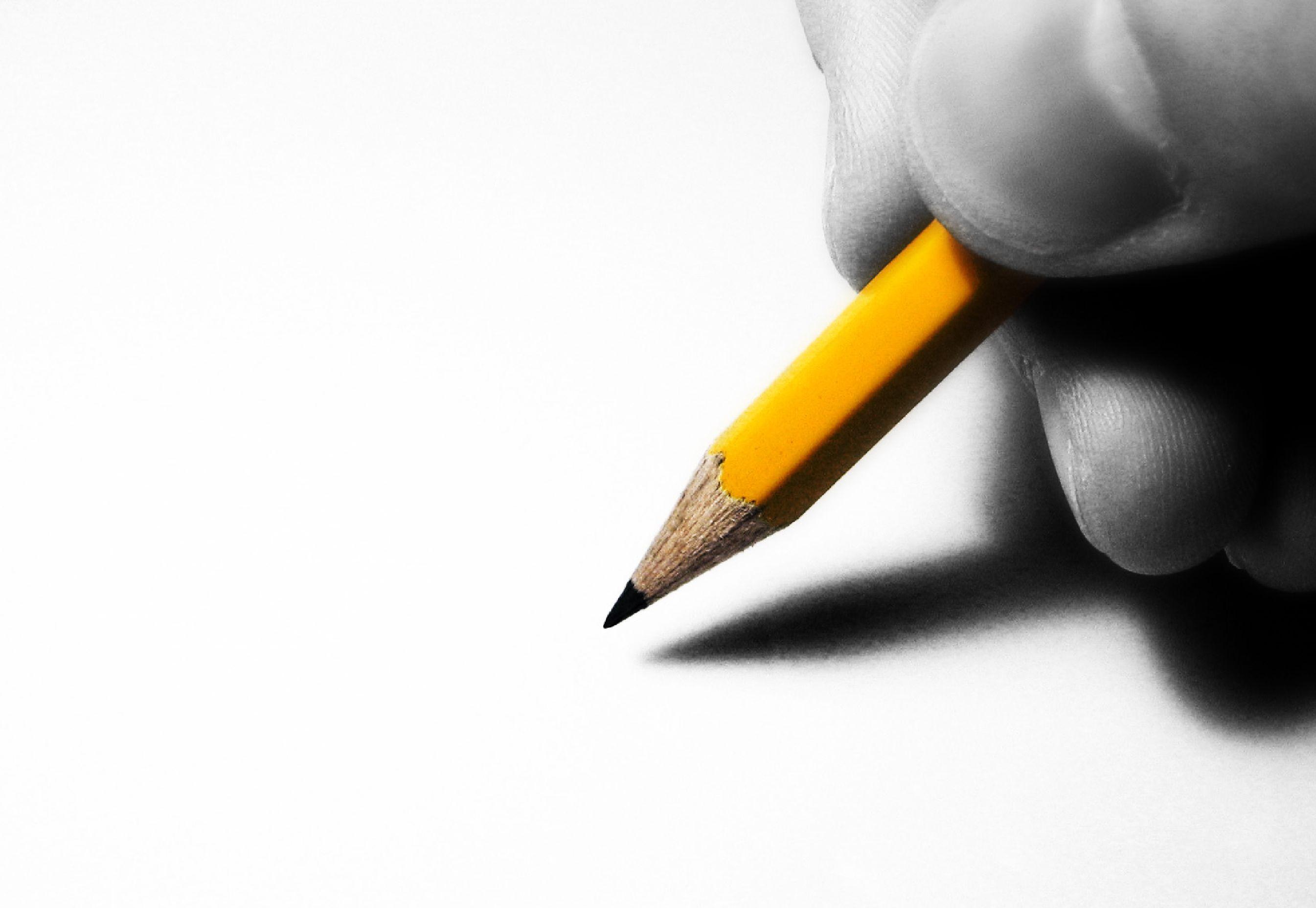 stock image of a pencil held near paper