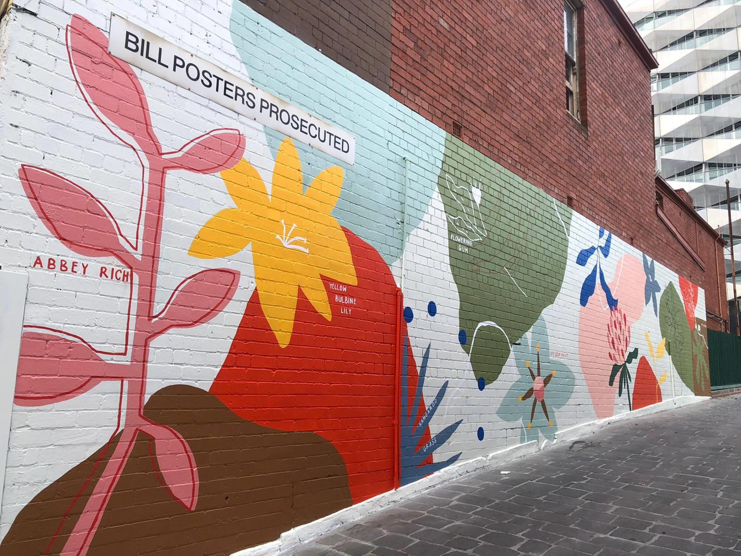 Picture of a brightly coloured floral mural on a brick wall