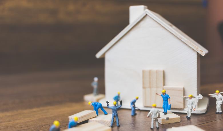 Stock photo of model figures building a house