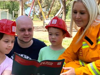 Two emergency workers reading to two kids