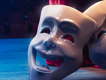 Drama and comedy masks in front of red curtain